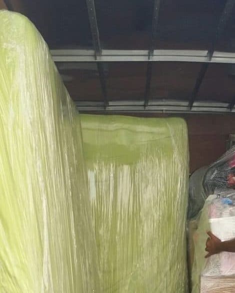 Wrapped mattresses and sealed boxes loaded and secured inside the truck for a long distance move